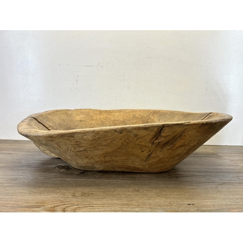 597 - A 19th century carved elm dough bowl - approx. 16cm high x 66cm long x 40cm wide