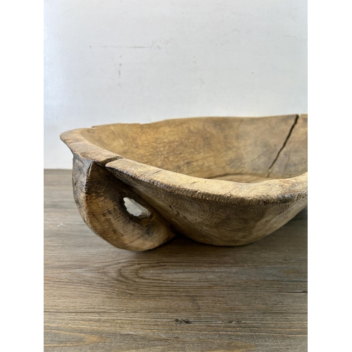 597 - A 19th century carved elm dough bowl - approx. 16cm high x 66cm long x 40cm wide