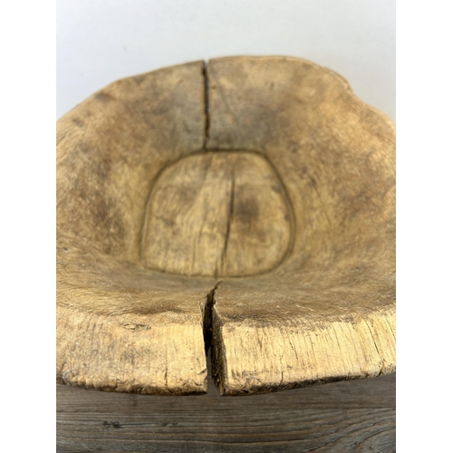 597 - A 19th century carved elm dough bowl - approx. 16cm high x 66cm long x 40cm wide