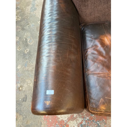 35 - A brown leather and fabric upholstered four seater sofa - approx. 79cm high x 252cm x 106cm