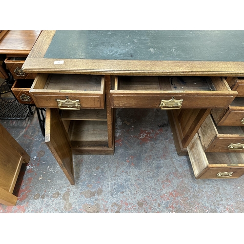 53 - An early 20th century oak pedestal writing desk - approx. 77cm high x 121cm wide x 66cm deep