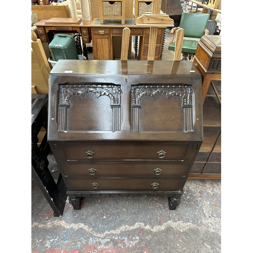 198 - A mid 20th century carved oak bureau - approx. 100cm high x 76cm wide x 40cm deep