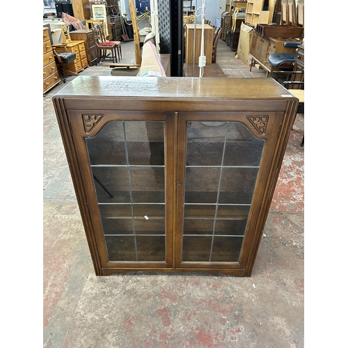 239 - A Jentique carved oak bookcase with two lead glazed doors - approx. 107cm high x 91cm wide x 31cm de... 