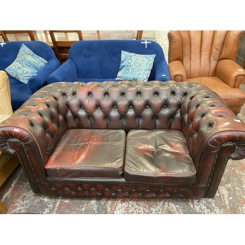 244 - An oxblood leather Chesterfield two seater sofa