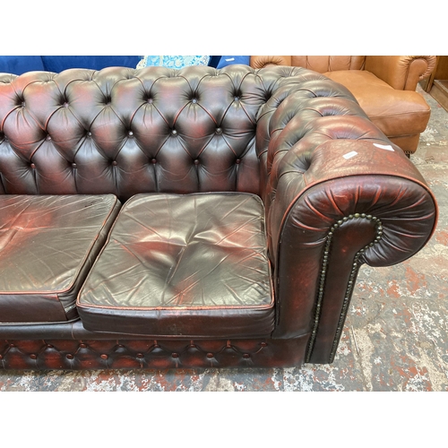 244 - An oxblood leather Chesterfield two seater sofa