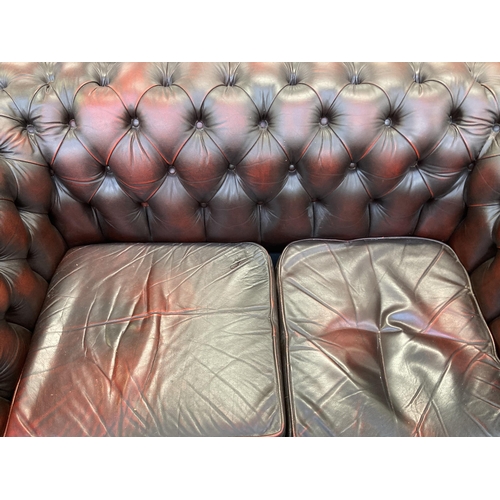 244 - An oxblood leather Chesterfield two seater sofa