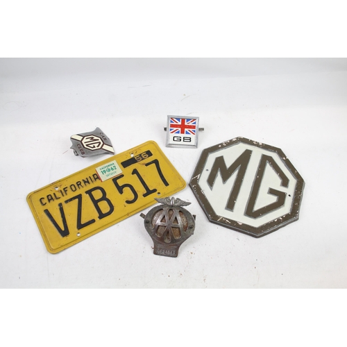 1125 - Five items of automobilia to include car badges, license plate etc.