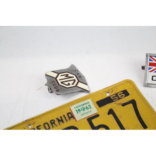 1125 - Five items of automobilia to include car badges, license plate etc.