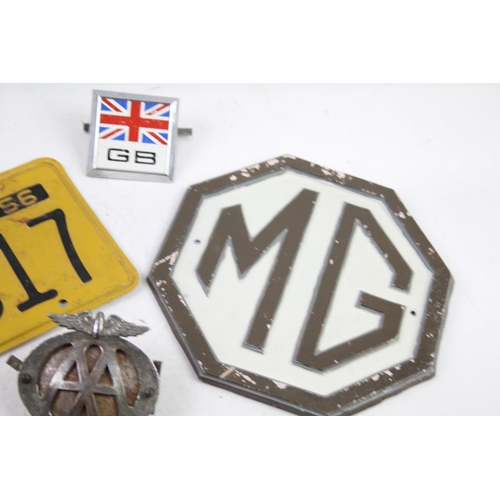 1125 - Five items of automobilia to include car badges, license plate etc.