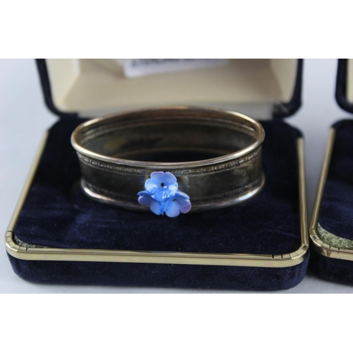 2454C - Four cased .925 sterling silver napkin rings with porcelain flowers - approx. gross weight 40g