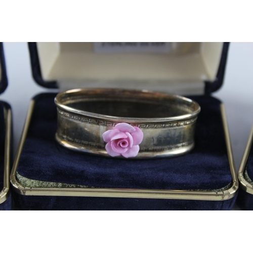 2454C - Four cased .925 sterling silver napkin rings with porcelain flowers - approx. gross weight 40g