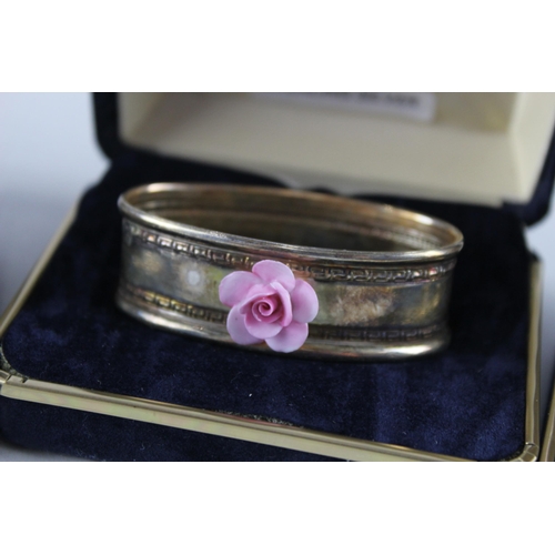 2454C - Four cased .925 sterling silver napkin rings with porcelain flowers - approx. gross weight 40g