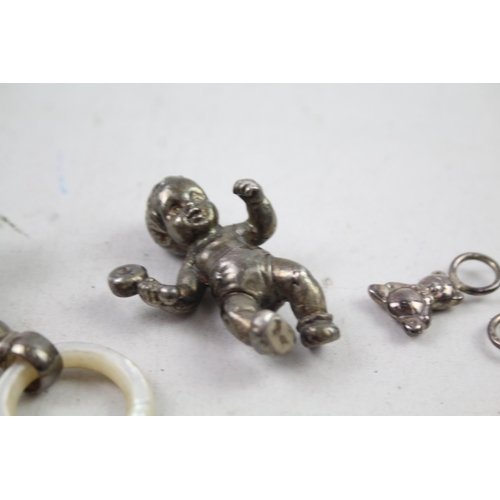 2454H - Four hallmarked sterling silver items to include baby rattles etc. - approx. gross weight 82g