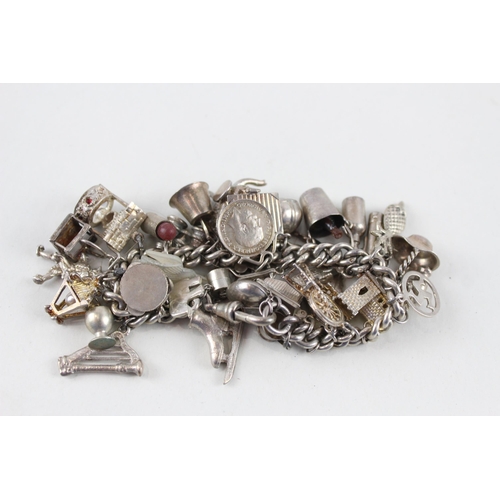 2344 - A silver charm bracelet with assorted charms - approx. gross weight 99g