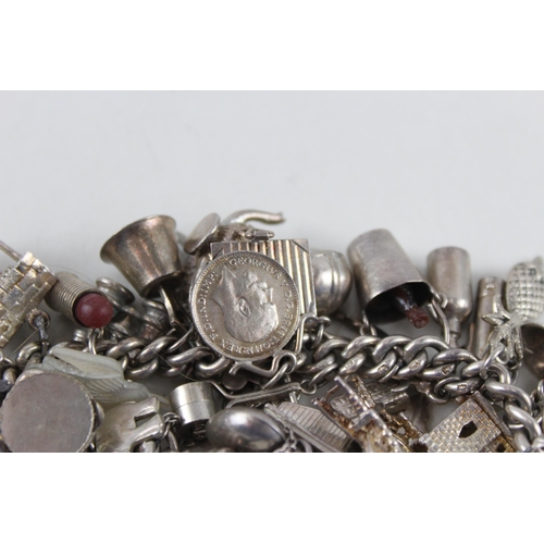 2344 - A silver charm bracelet with assorted charms - approx. gross weight 99g