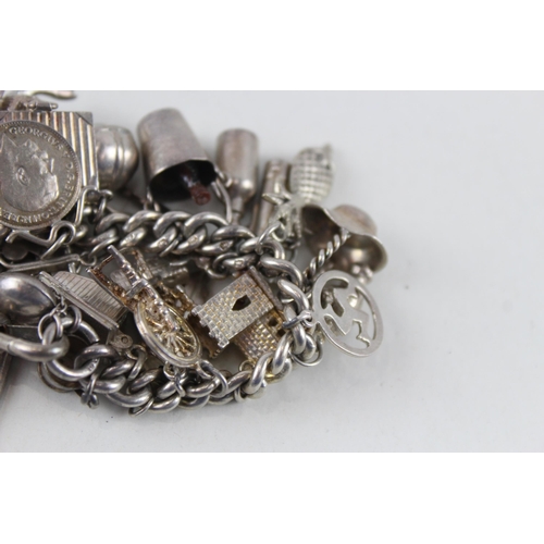 2344 - A silver charm bracelet with assorted charms - approx. gross weight 99g