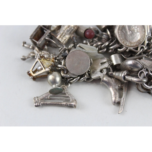 2344 - A silver charm bracelet with assorted charms - approx. gross weight 99g