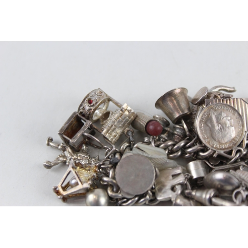 2344 - A silver charm bracelet with assorted charms - approx. gross weight 99g