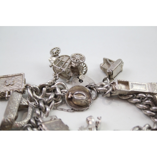 2348 - A silver charm bracelet with assorted charms - approx. gross weight 103g