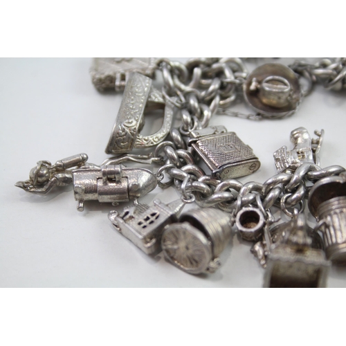 2348 - A silver charm bracelet with assorted charms - approx. gross weight 103g