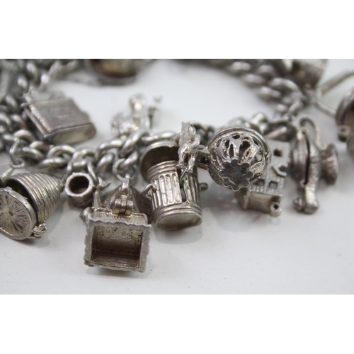 2348 - A silver charm bracelet with assorted charms - approx. gross weight 103g