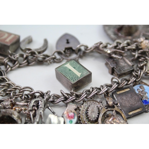 2349 - A silver charm bracelet with assorted charms - approx. gross weight 69g