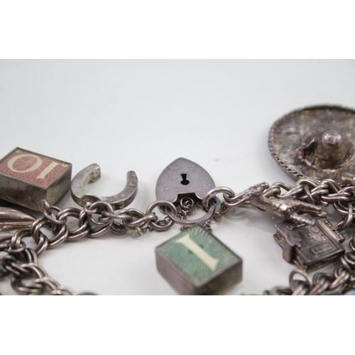 2349 - A silver charm bracelet with assorted charms - approx. gross weight 69g