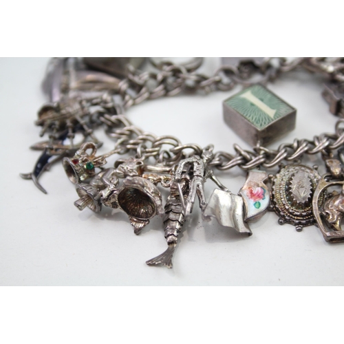 2349 - A silver charm bracelet with assorted charms - approx. gross weight 69g