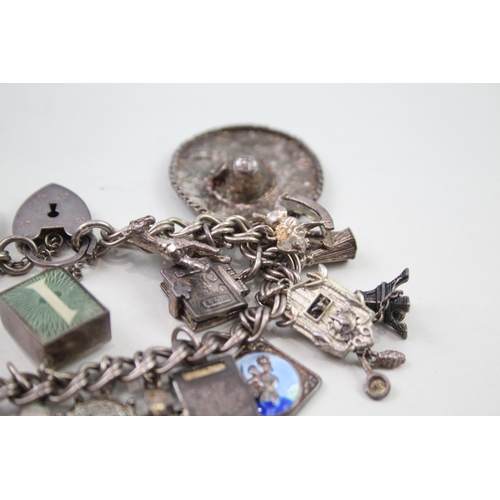 2349 - A silver charm bracelet with assorted charms - approx. gross weight 69g