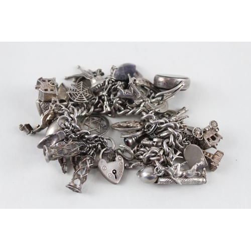 2387 - A silver charm bracelet with assorted charms - approx. gross weight 144g