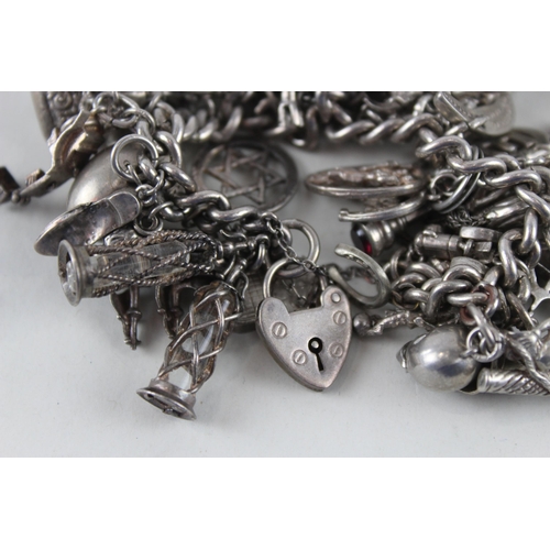 2387 - A silver charm bracelet with assorted charms - approx. gross weight 144g