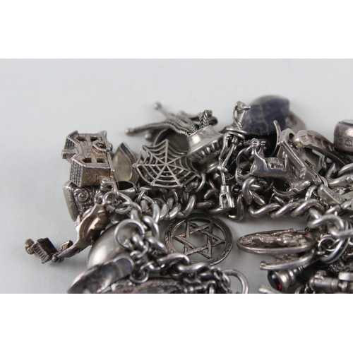 2387 - A silver charm bracelet with assorted charms - approx. gross weight 144g