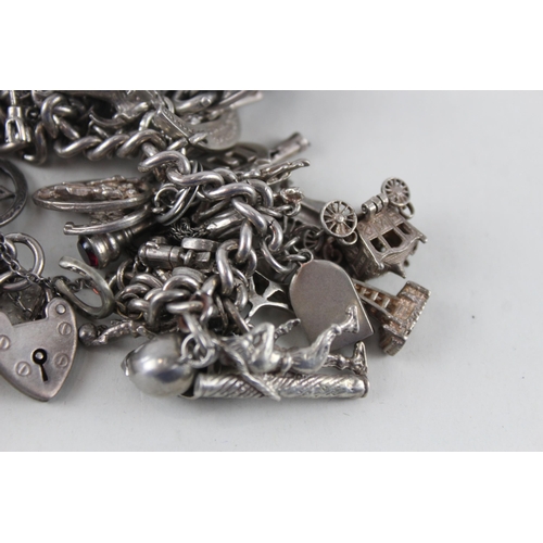 2387 - A silver charm bracelet with assorted charms - approx. gross weight 144g