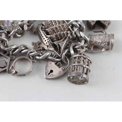 2390 - A silver charm bracelet with assorted charms - approx. gross weight 97g