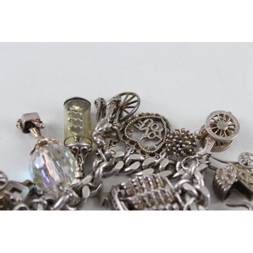 2390 - A silver charm bracelet with assorted charms - approx. gross weight 97g