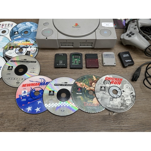 451 - Two Sony PlayStation consoles with games and accessories to include Grand Theft Auto, Spyro, Tekken ... 