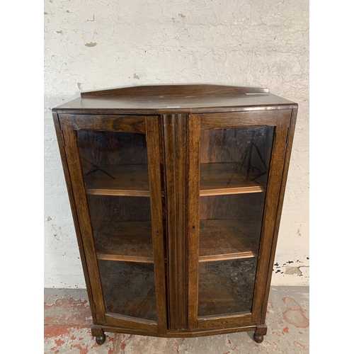 103 - A 1930s oak bookcase with two glazed doors - approx. 110cm high x 74cm wide x 32cm deep