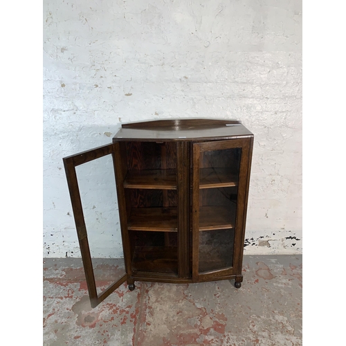 103 - A 1930s oak bookcase with two glazed doors - approx. 110cm high x 74cm wide x 32cm deep