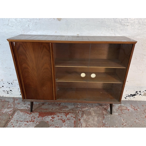 106 - A mid 20th century walnut bookcase with two glass sliding doors - approx. 84cm high x 109cm wide x 2... 