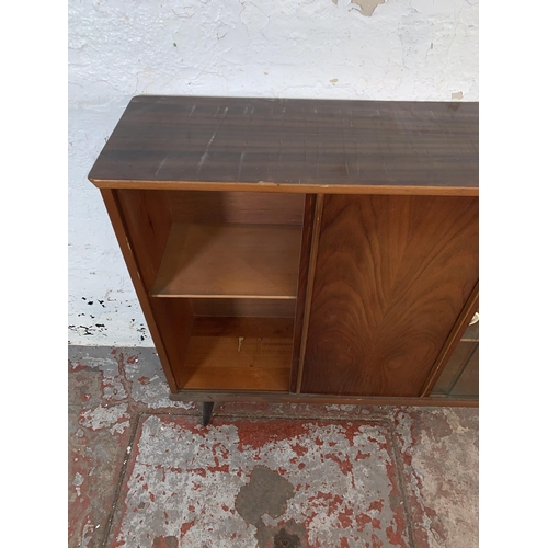 106 - A mid 20th century walnut bookcase with two glass sliding doors - approx. 84cm high x 109cm wide x 2... 