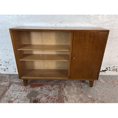 107 - A mid 20th century Lebus oak bookcase with two glass sliding doors - approx. 80cm high x 107cm wide ... 