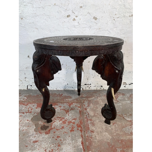 237 - A Burmese carved teak circular occasional table with elephant design supports - approx. 63cm high x ... 