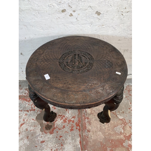 237 - A Burmese carved teak circular occasional table with elephant design supports - approx. 63cm high x ... 