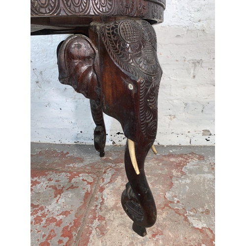 237 - A Burmese carved teak circular occasional table with elephant design supports - approx. 63cm high x ... 