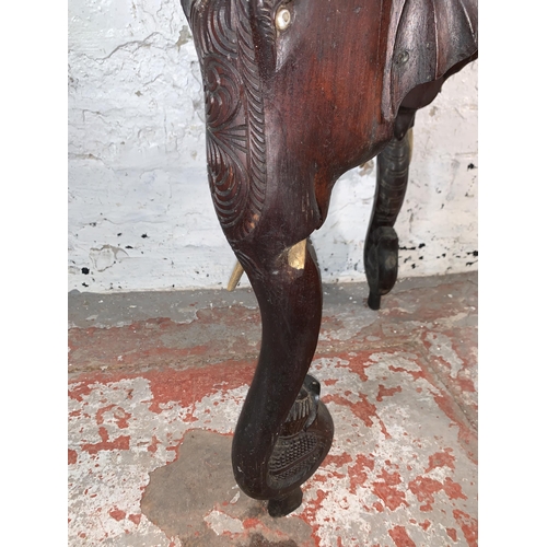 237 - A Burmese carved teak circular occasional table with elephant design supports - approx. 63cm high x ... 