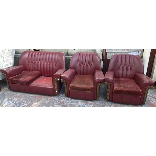 241 - An Art Deco red vinyl and carved wooden three piece lounge suite comprising two seater sofa and two ... 