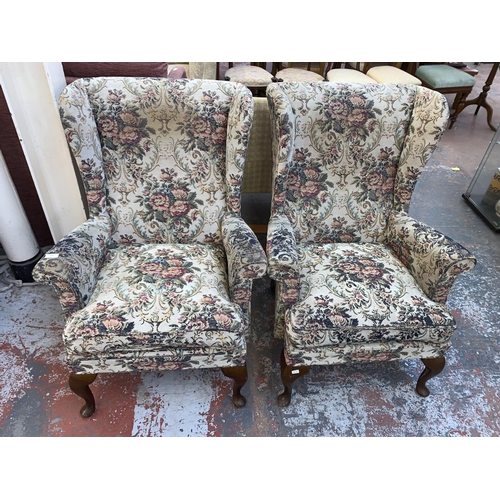 242 - A pair of mid 20th century floral fabric upholstered wingback armchairs