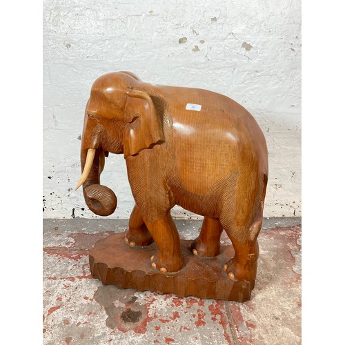 209 - A carved teak elephant statue - approx. 70cm high x 21cm wide x 58cm long