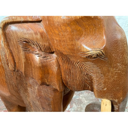 209 - A carved teak elephant statue - approx. 70cm high x 21cm wide x 58cm long