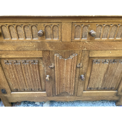 113 - An L. Marcus Ltd. carved oak linenfold sideboard - approx. 93cm high x 122cm wide x 48cm deep